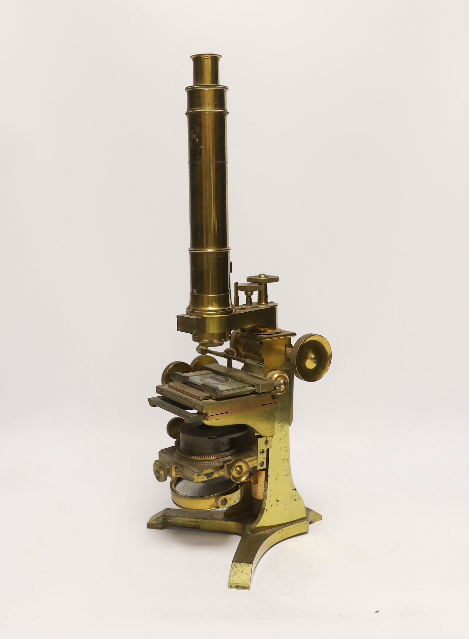 A brass microscope with mahogany box by A. Ross of London, dated 1890 to foot, with some unusual features including a rotating box under the bed for lens, box with fitted interior containing additional lens and other att